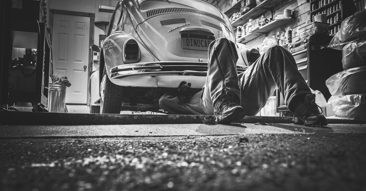 Mechanic working under a vehicle on a lift in an Ottawa auto repair shop